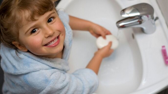 the child washes his hands with soap to avoid worms